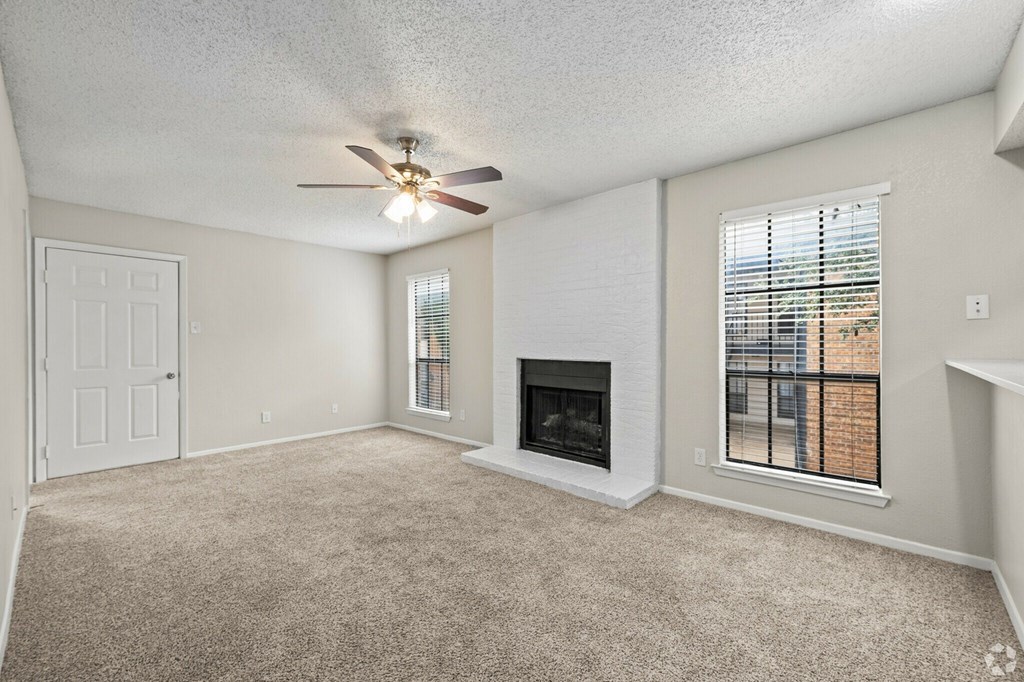 A room with a fireplace and a ceiling fan.