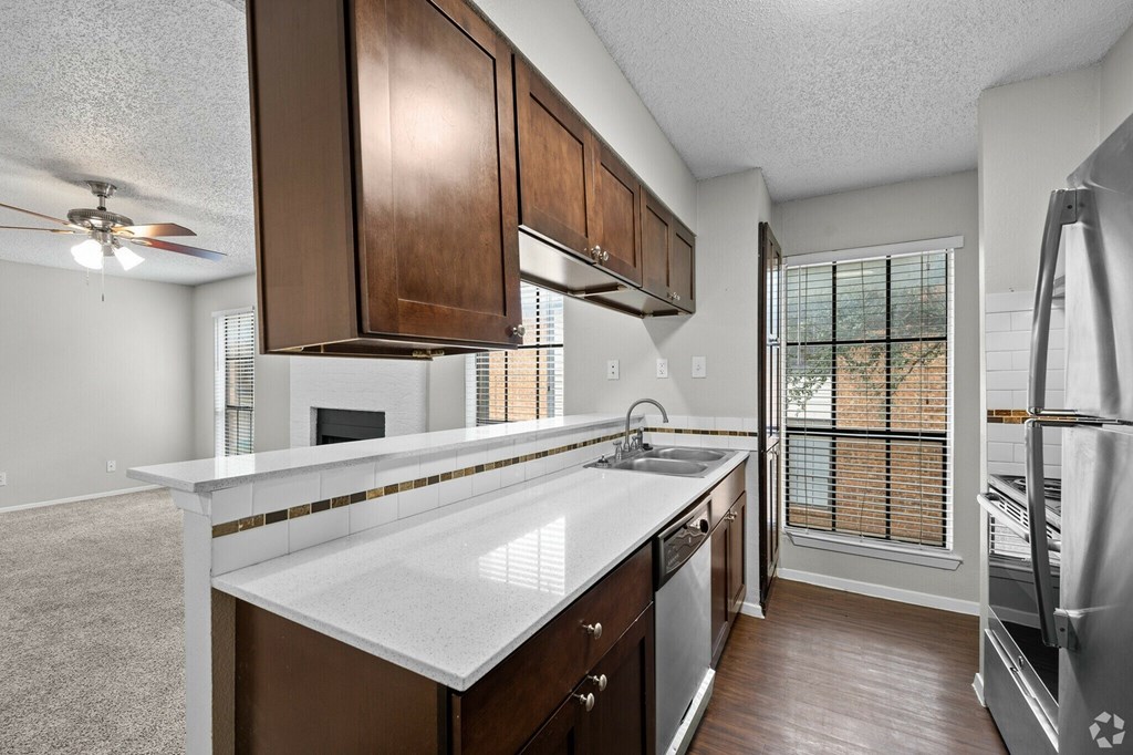 A kitchen with brown cabinets and a white countertop.