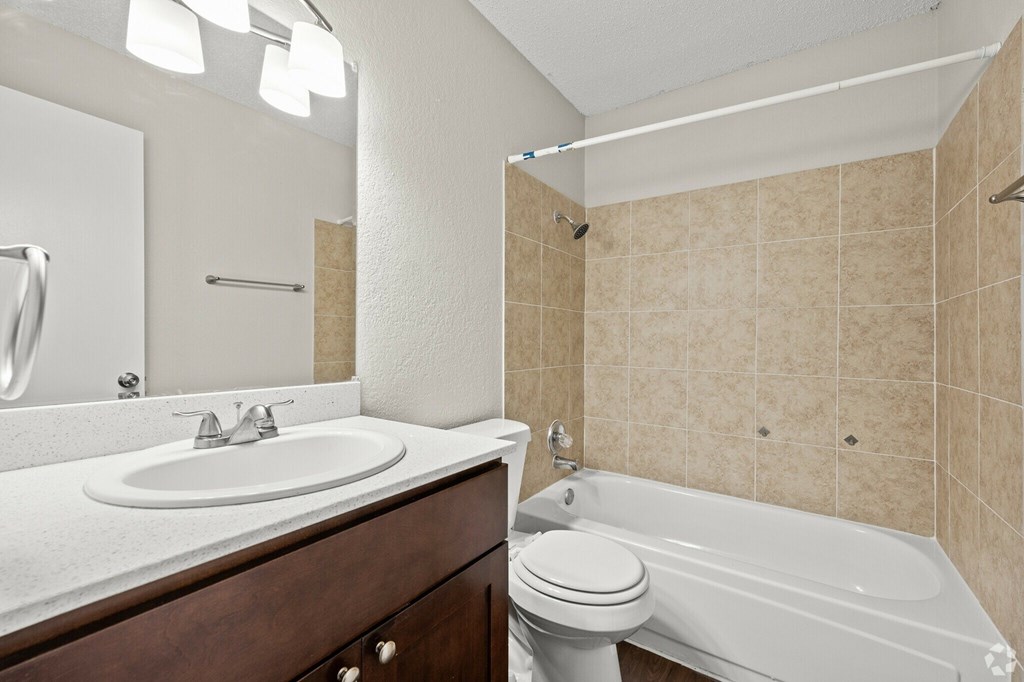 A bathroom with a white sink, toilet, and bathtub.