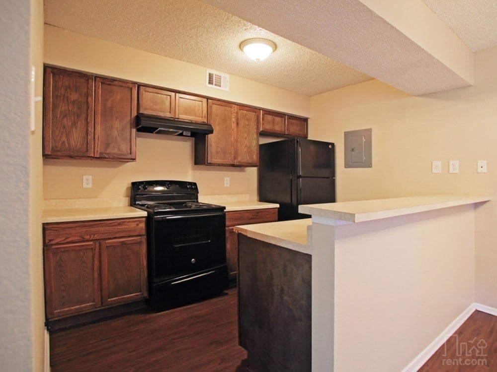 A kitchen with wooden cabinets and a black stove top oven.