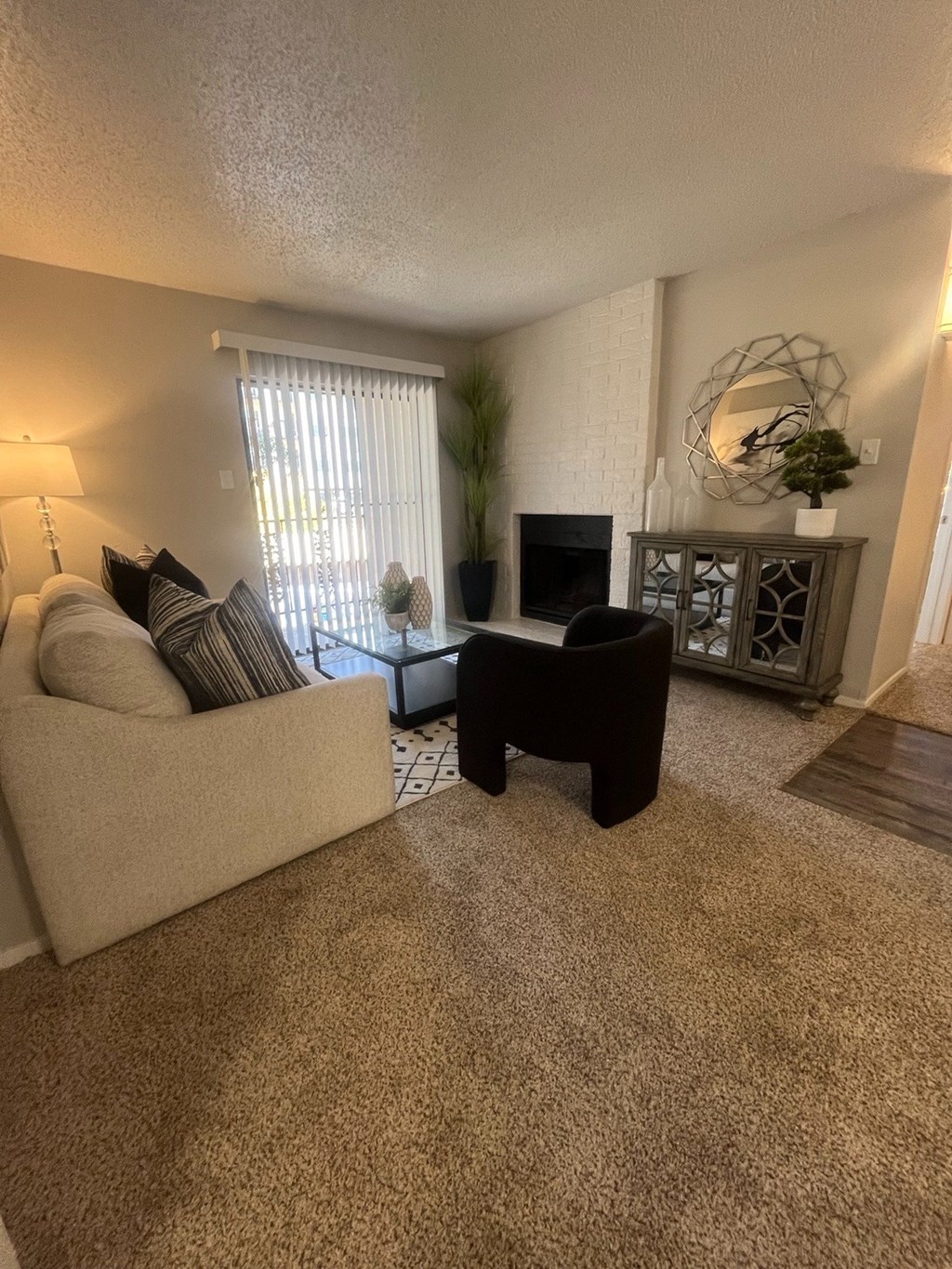 A living room with a couch, chair, and fireplace.