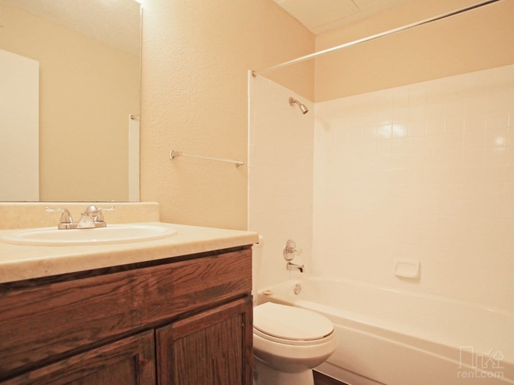 A bathroom with a toilet, sink, and bathtub.