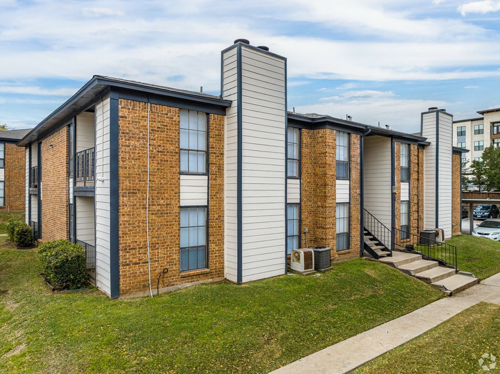 A row of houses with a grassy front yard.