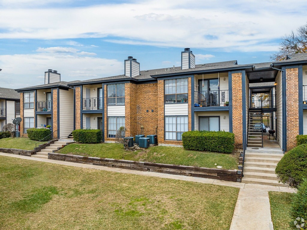 A row of townhouses with a grassy front yard.