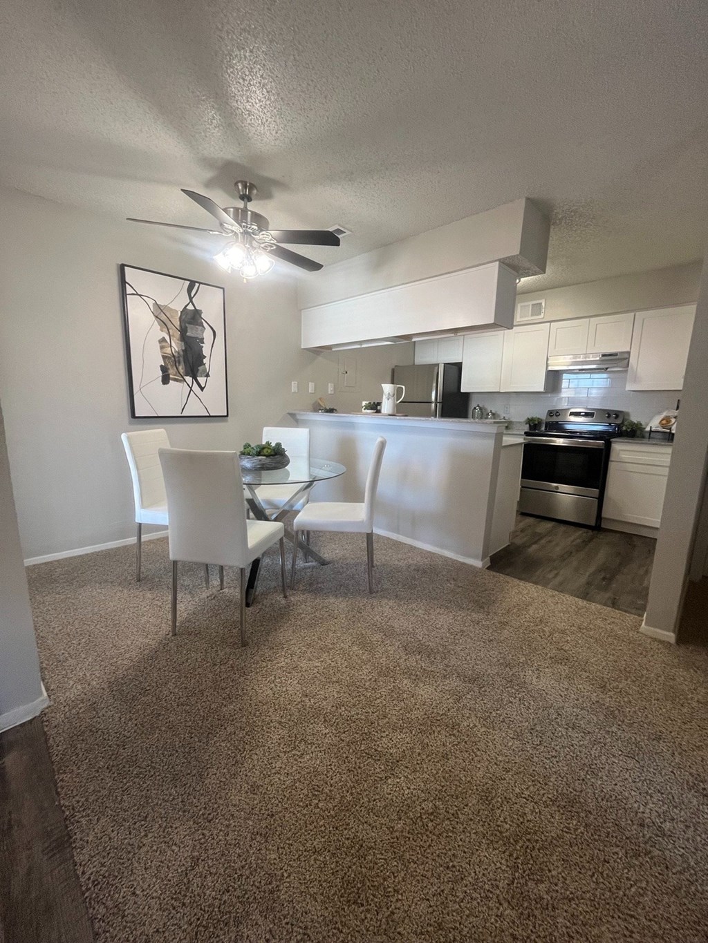 A kitchen with a dining table and chairs.