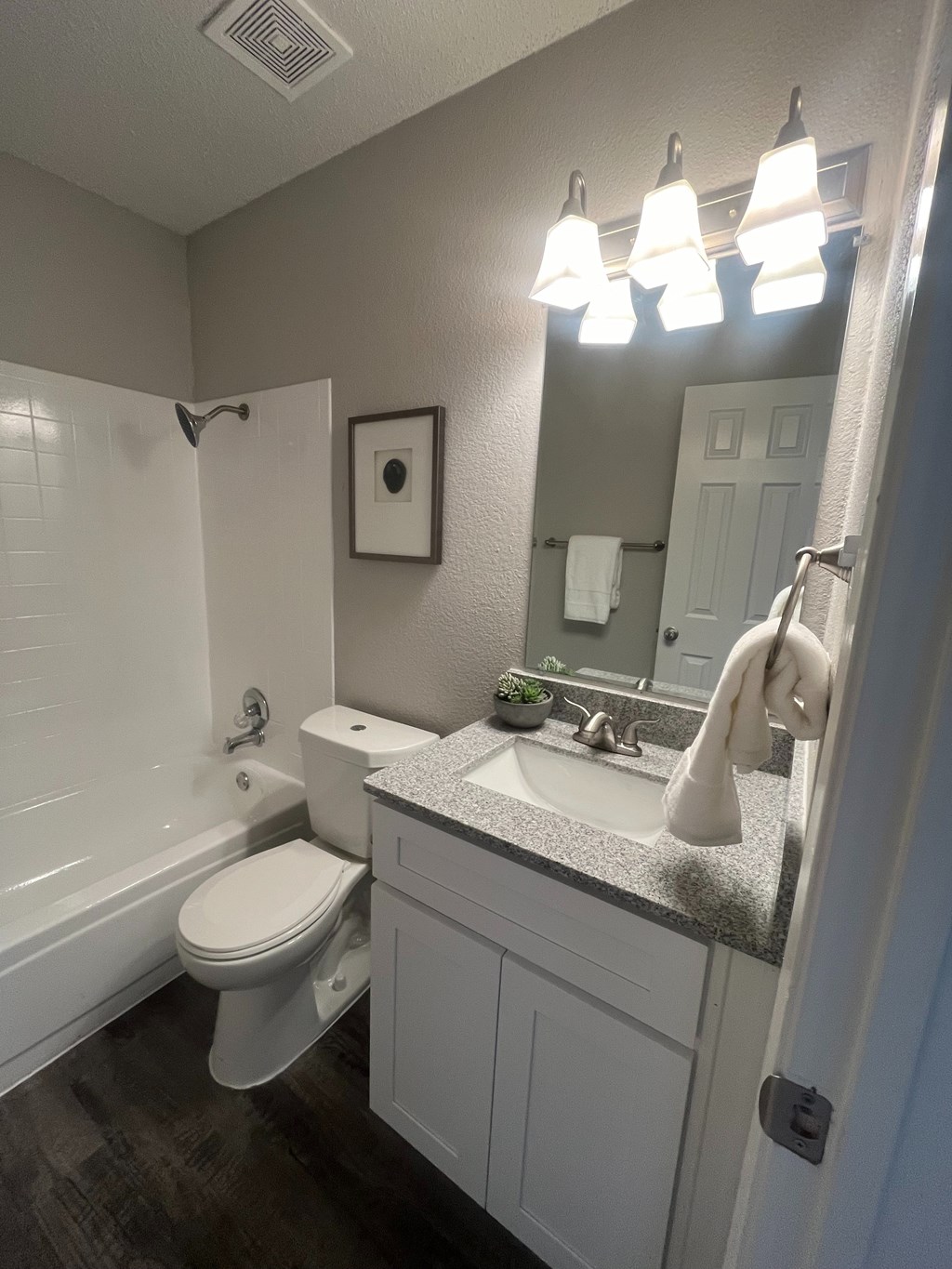 A bathroom with a toilet, sink, and mirror.