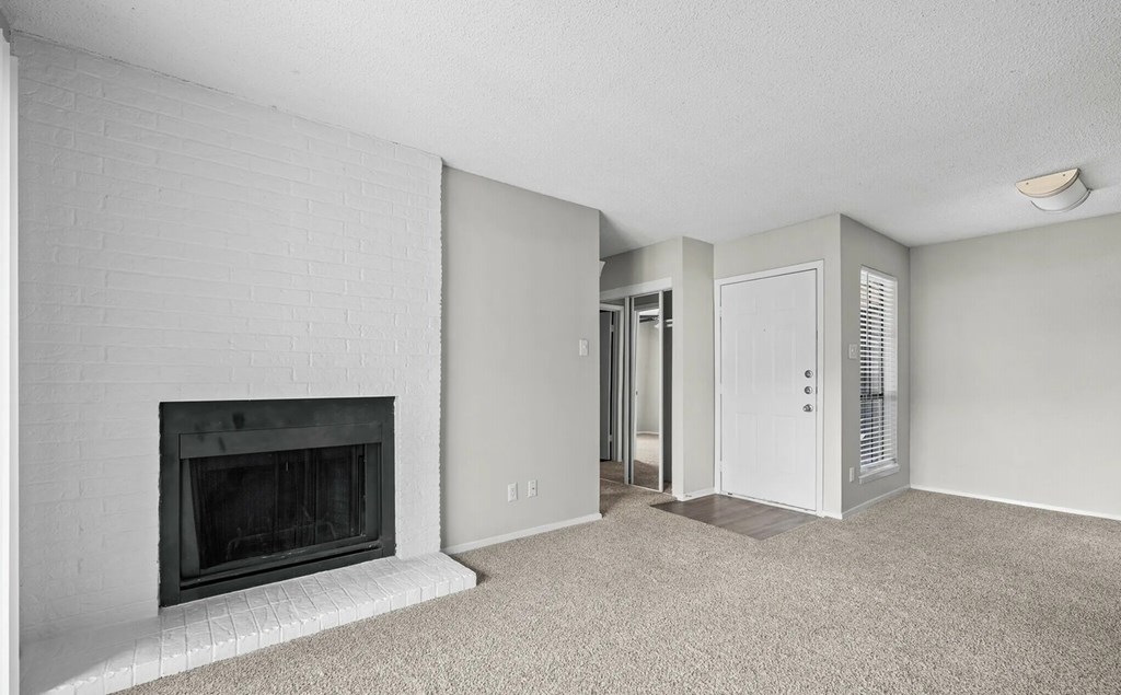 A white room with a fireplace and a carpeted floor.
