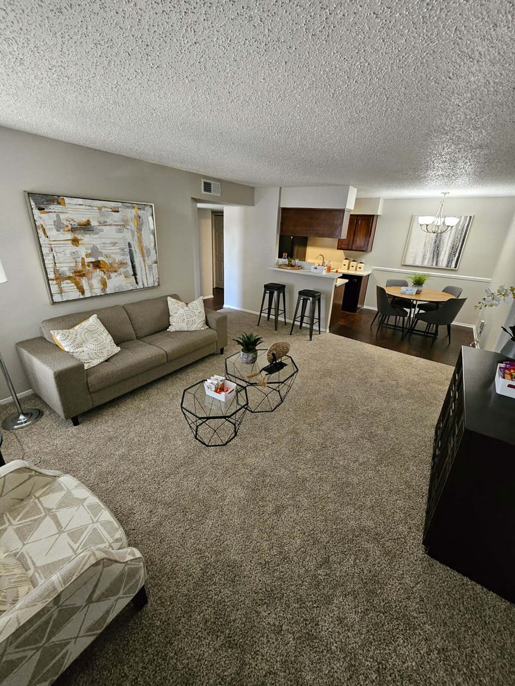 A living room with a couch, chair, and a painting on the wall.