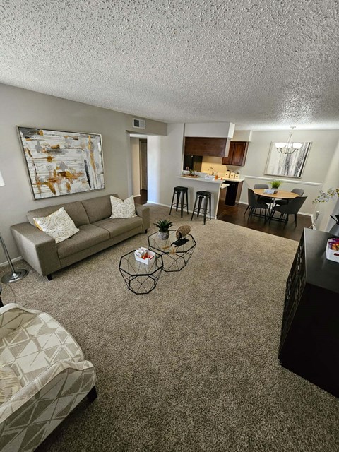 A living room with a couch, chair, and a painting on the wall.