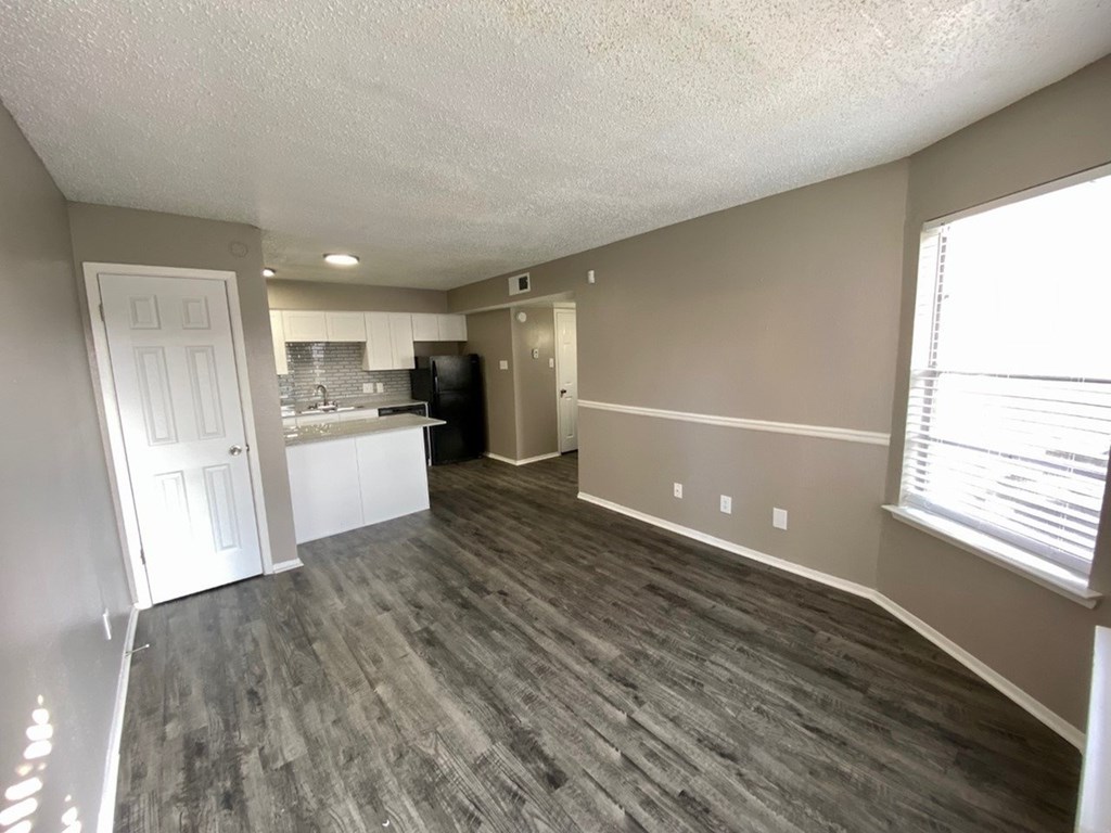A kitchen area with a refrigerator, sink, and cabinets.