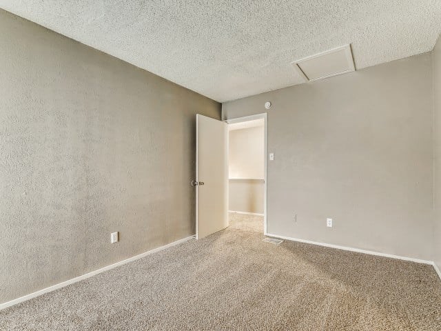 A room with a carpeted floor and a closed door.
