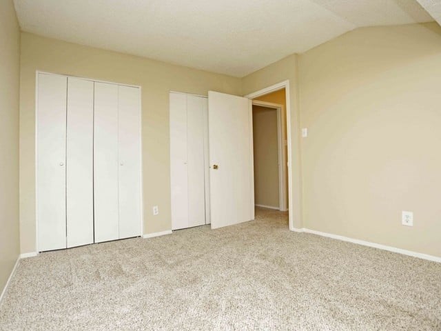 A room with a carpeted floor and a white door.