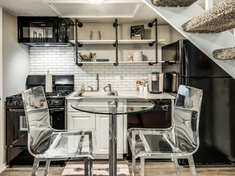 A modern kitchen with a glass table and chairs.