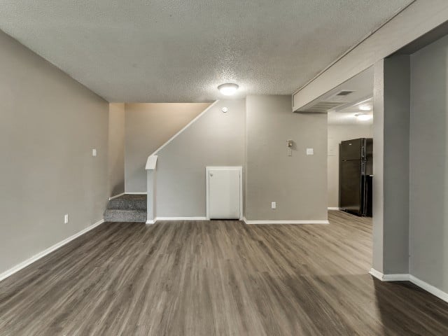 A room with a white door and a staircase leading to another room.