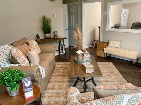 A living room with a sofa, armchair, and coffee table.