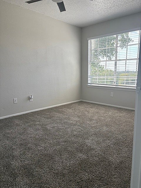 A room with a carpeted floor and a window with blinds.