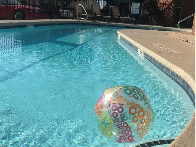 A colorful ball is floating in a blue pool.