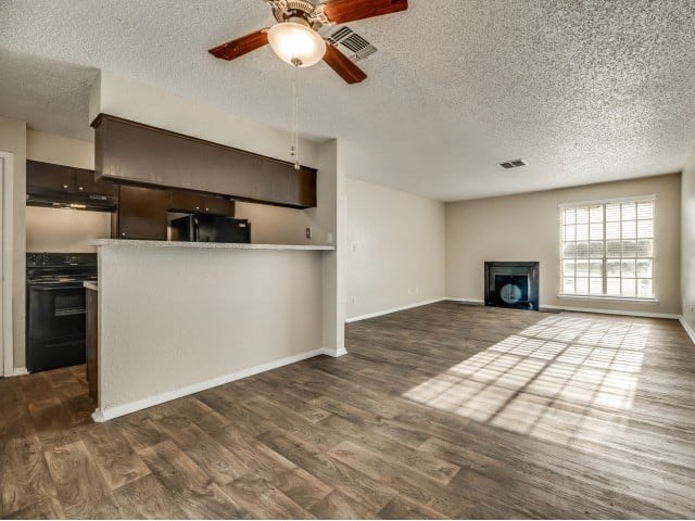 A room with a fireplace and a ceiling fan.