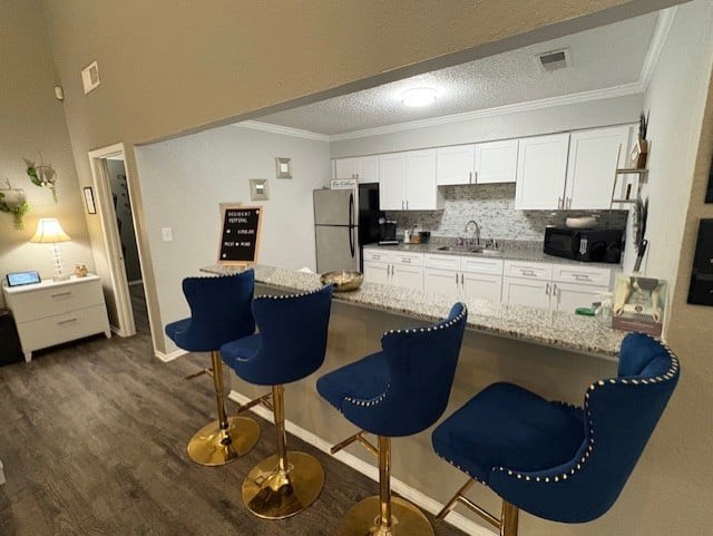 A kitchen with a black stove top oven and white cabinets.