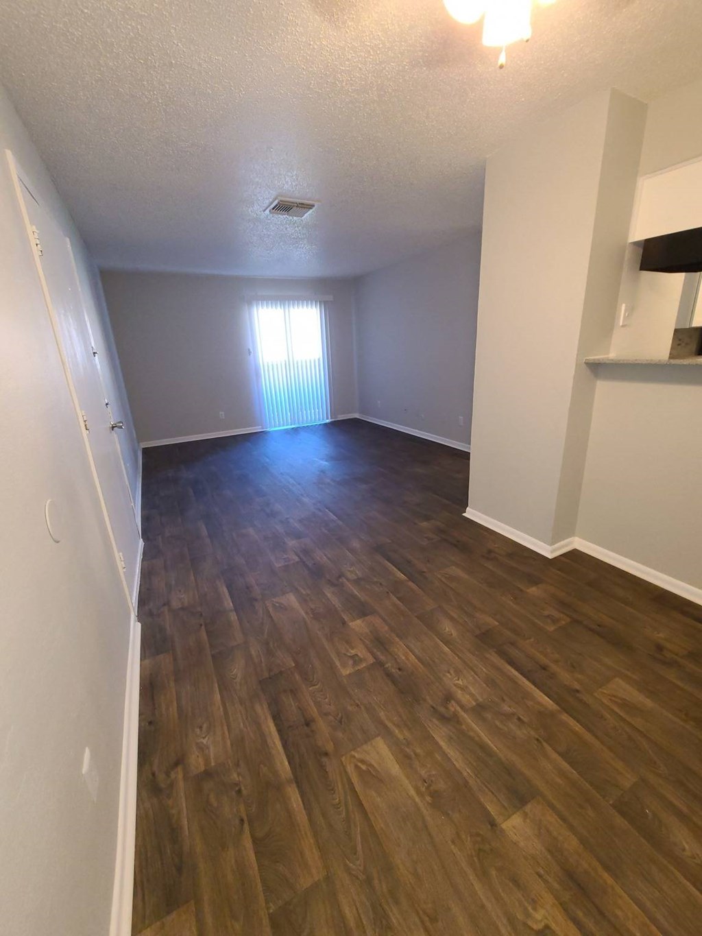 A room with wooden flooring and white walls.