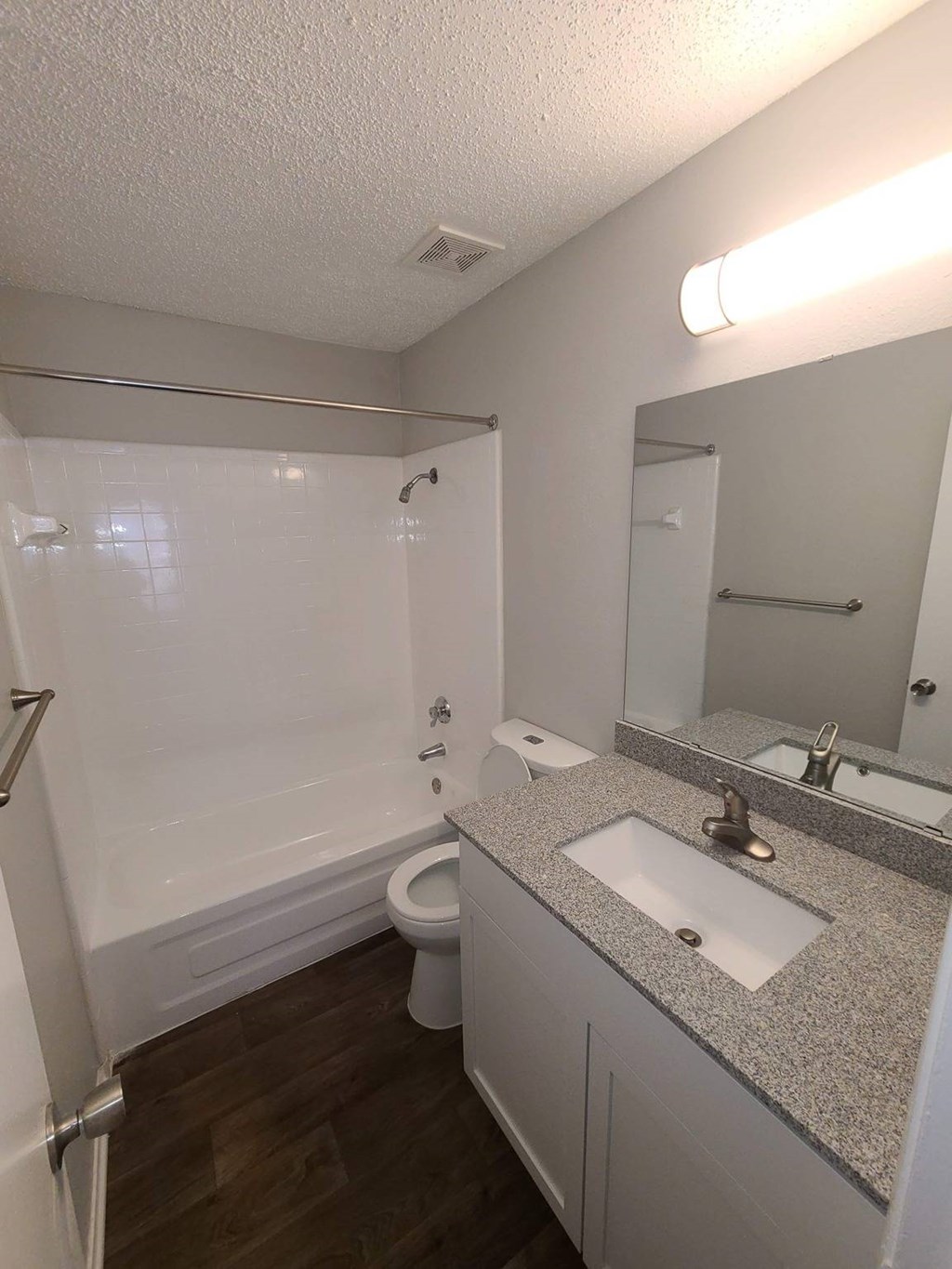 A bathroom with a toilet, sink, and mirror.