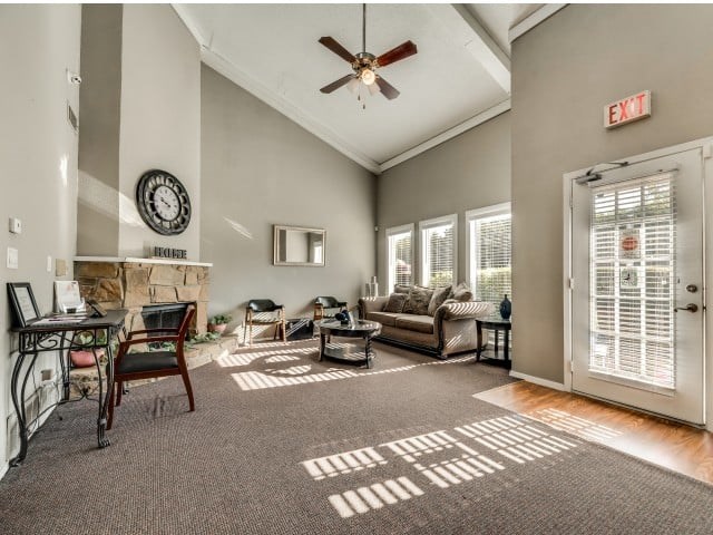 A living room with a fireplace and a ceiling fan.