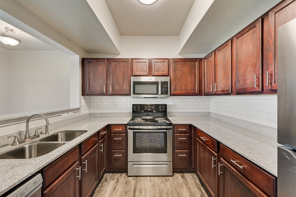 A kitchen with wooden cabinets and stainless steel appliances.