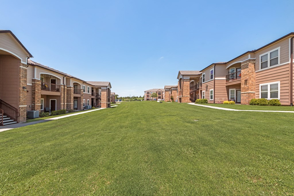 A row of houses with a green lawn in front.