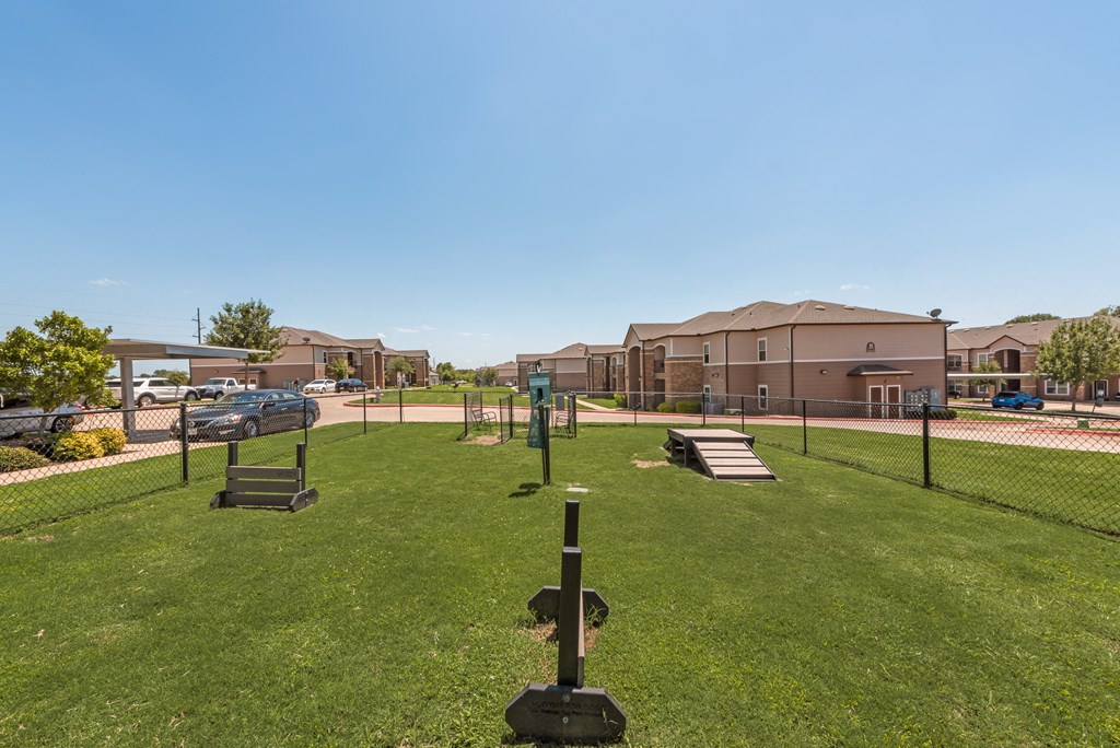 A park with a swing set and a green lawn.