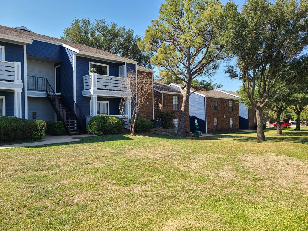 A grassy area in front of apartment buildings.