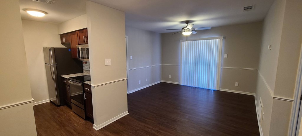 A kitchen area with a black fridge and stove top oven.
