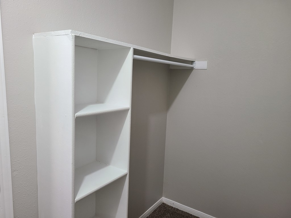 A white bookshelf in a corner of a room.