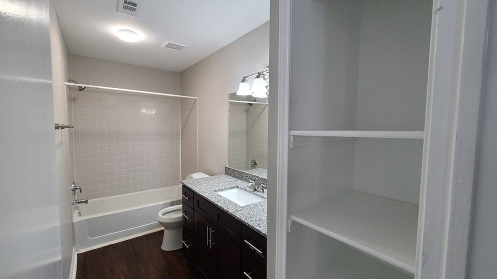 A white bathroom with a toilet, sink, and shower.