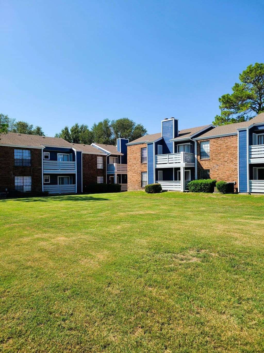 A grassy area in front of apartment buildings.
