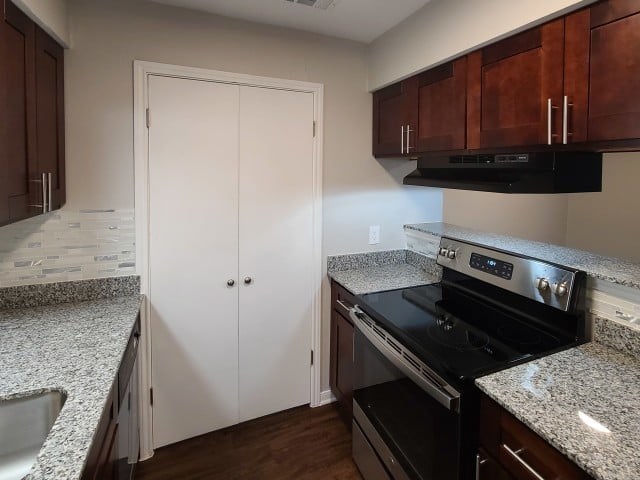 A kitchen with a black stove top oven and white cabinets.