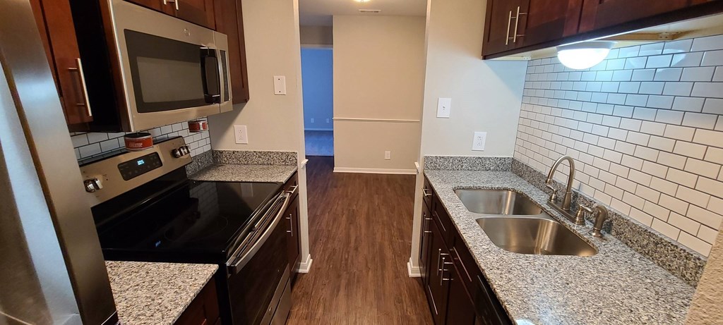 A kitchen with a sink and a microwave.