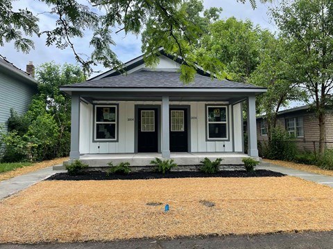 A small house with a black door and white trim.