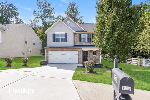 A house with a driveway and a mailbox in front.