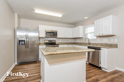 A kitchen with a granite countertop and stainless steel appliances.