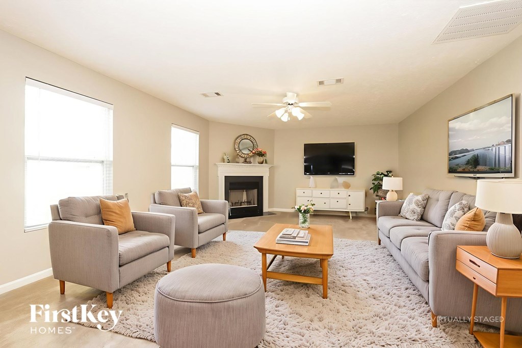 A living room with a grey couch, a coffee table, and a fireplace.
