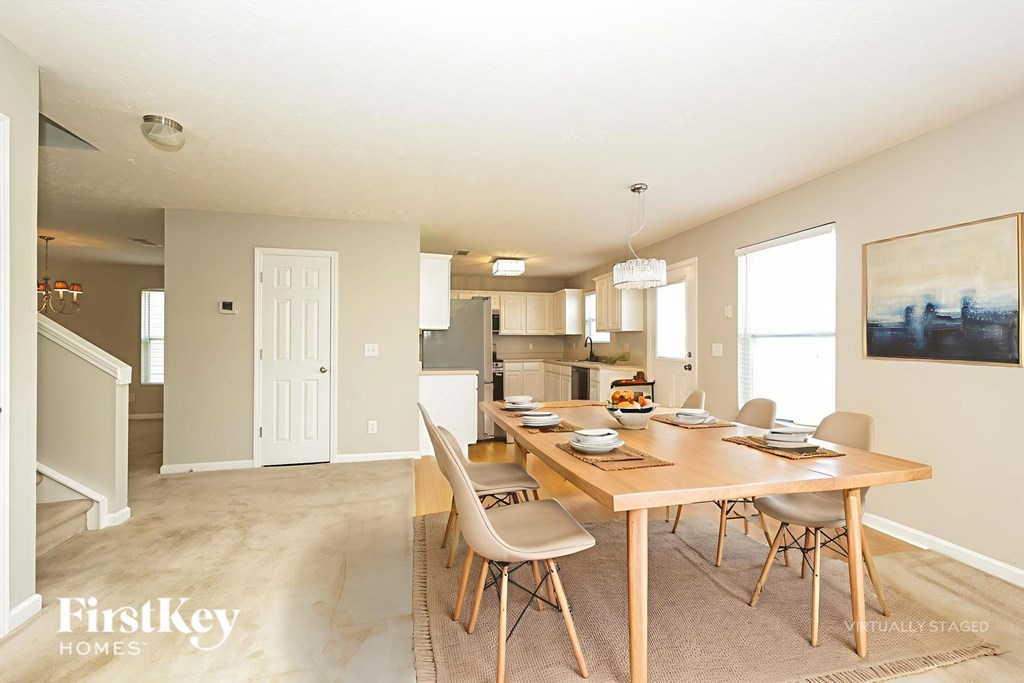 A dining room with a wooden table and chairs.