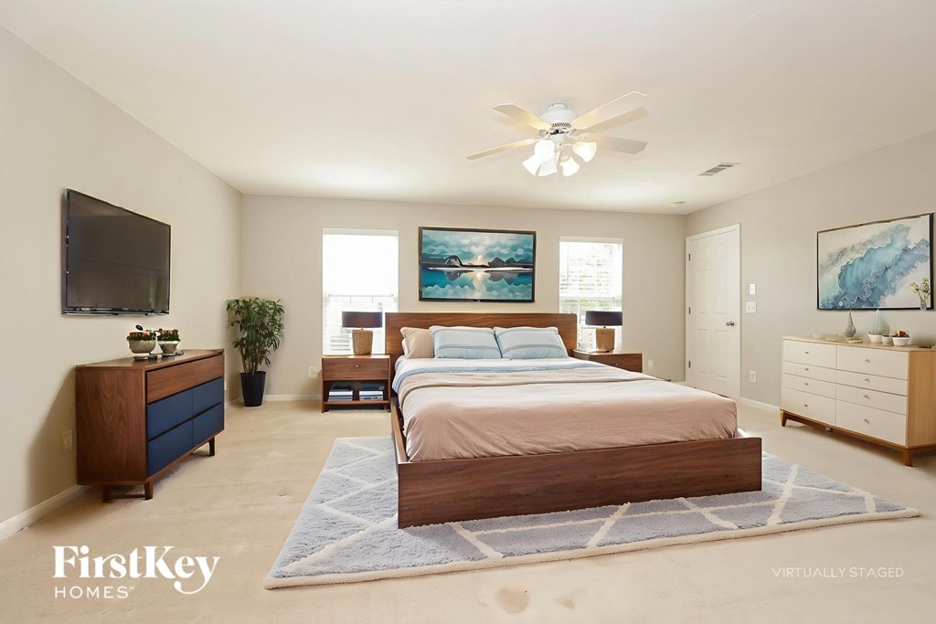 A bedroom with a bed, dresser, and tv.