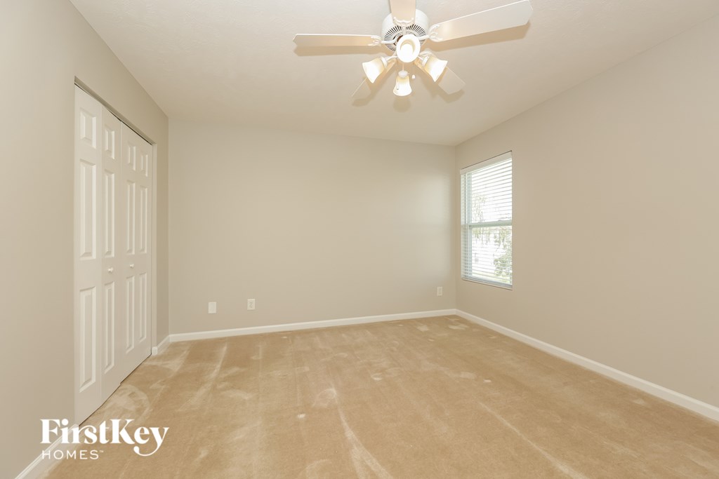 A room with a ceiling fan and a door.