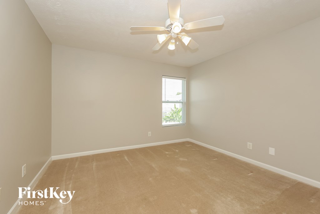 A room with a ceiling fan and a window.