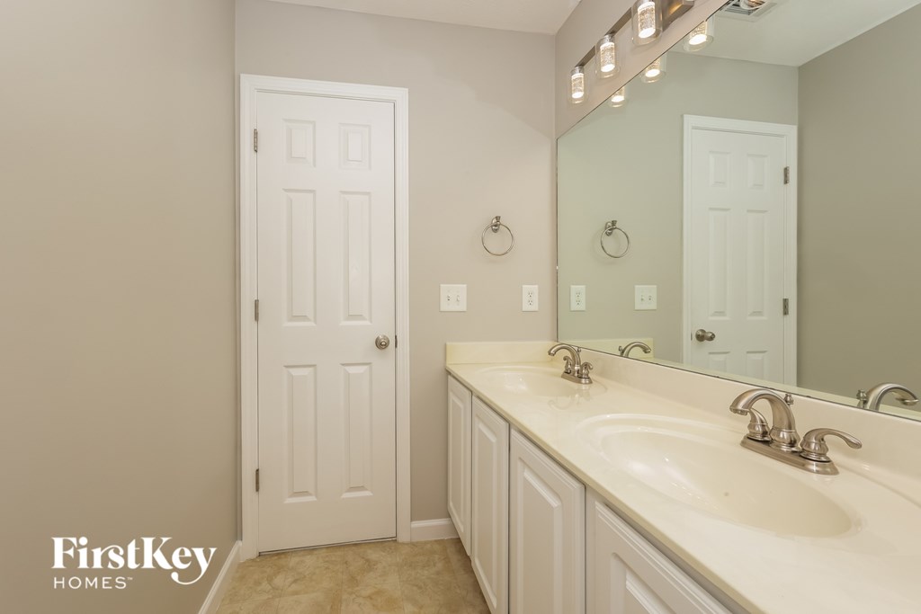 A bathroom with a white door and a white sink.