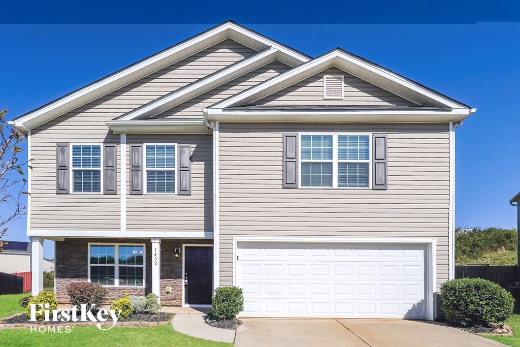 A two-story house with a garage and a driveway.