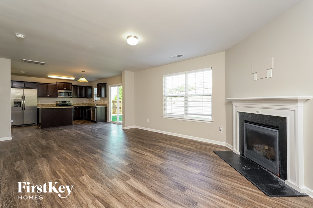 A spacious living room with a fireplace and wooden flooring.