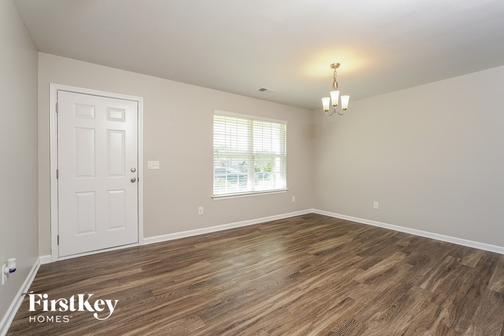 A room with wooden flooring and a white door.