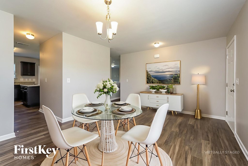 A dining room with a glass table and white chairs.