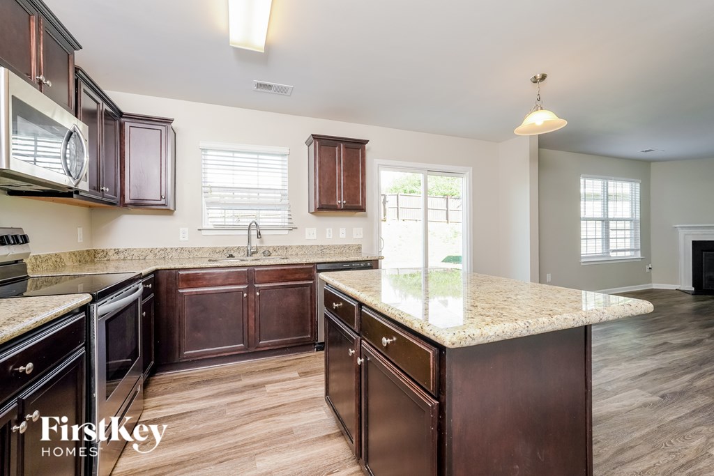 A kitchen with brown cabinets and a granite countertop.